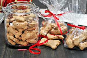 44371107 - homemade dog bones being packaged into cellophane bags as healthy gifts for dogs. selective focus on foreground cookies.